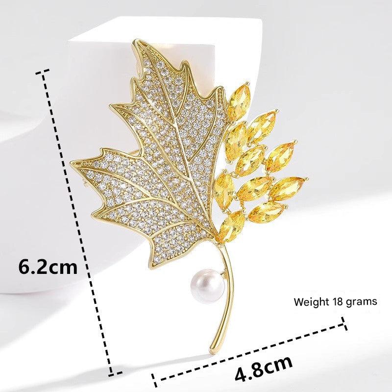 Golden maple leaf brooch with pearl accent
