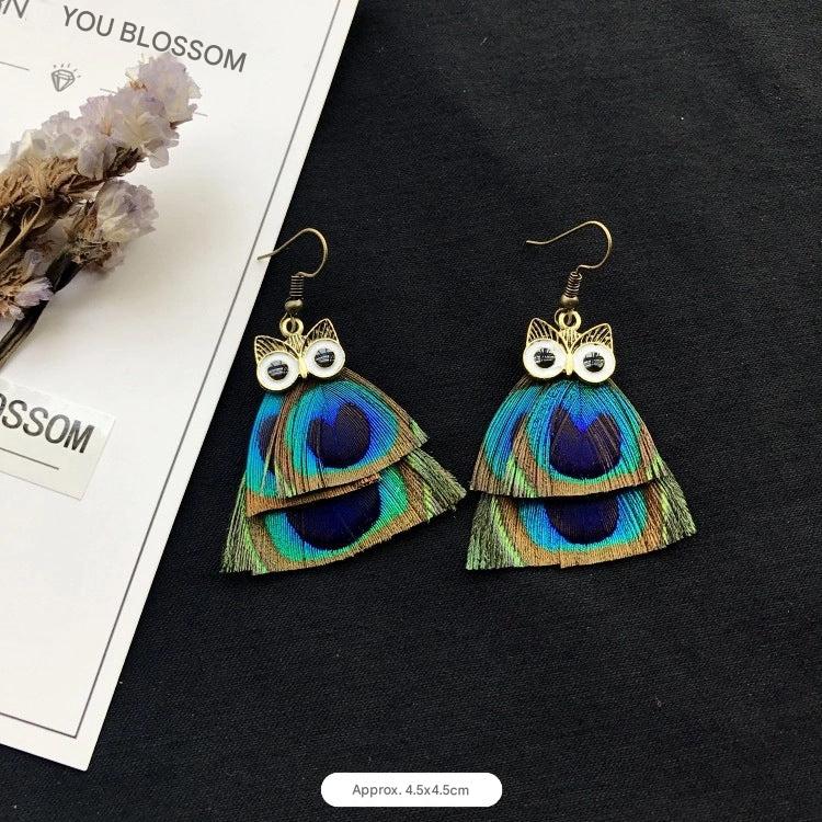 Peacock feather earrings displayed on a model