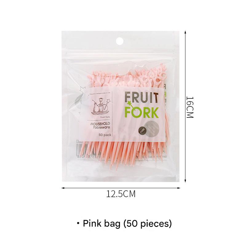 colorful disposable forks on a table with fruits