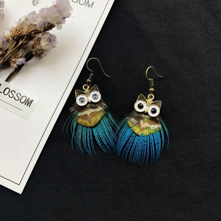 Peacock feather earrings displayed on a model